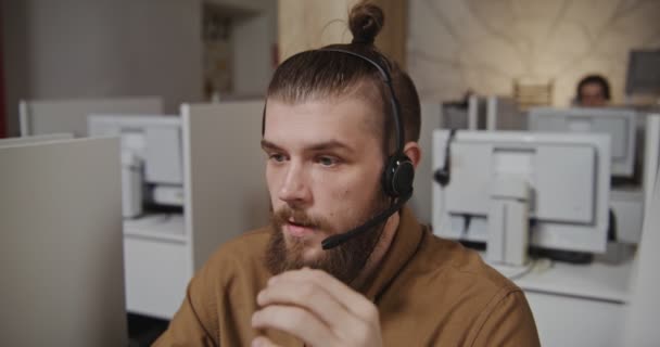 Callcenter-Betreiber schließt Mikrofon zum Schwur und setzt Gespräch fort — Stockvideo