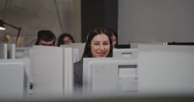 Çağrı merkezi çalışanı - kulaklıklı genç kadın müşteriyle iletişim kuruyor