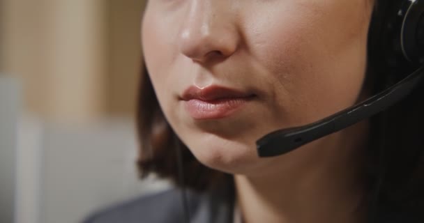 Call center arbetare - en ung man i hörlurar kommunicerar med en kund — Stockvideo