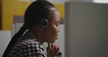 Çağrı merkezi çalışanı, kulaklıklı Afro-Amerikan kadın müşteriyle iletişim kuruyor.
