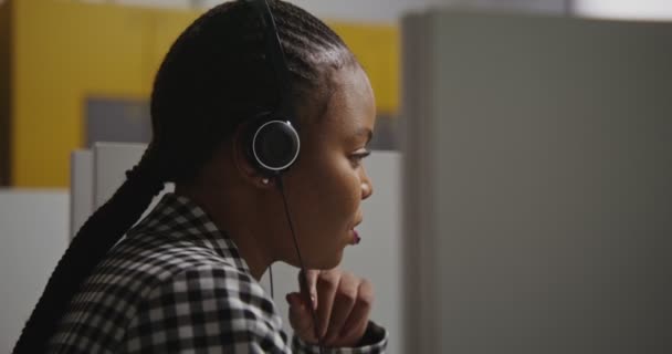 Call center arbejdstager afrikansk amerikansk kvinde i hovedtelefoner kommunikerer med klienten – Stock-video