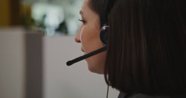 Çağrı merkezi çalışanı - kulaklıklı genç kadın müşteriyle iletişim kuruyor