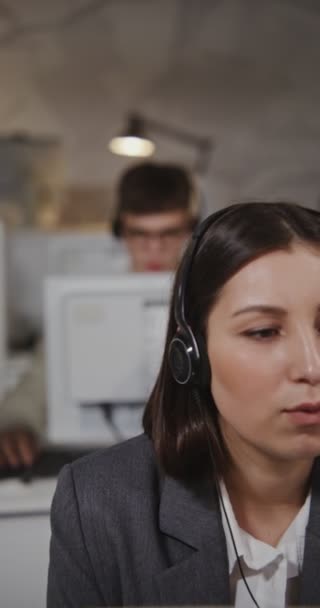 Працівники колл-центру - молодий чоловік і жінка спілкуються з клієнтами — стокове відео