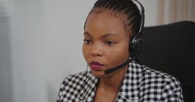 Çağrı merkezi çalışanı, kulaklıklı Afro-Amerikan kadın müşteriyle iletişim kuruyor.