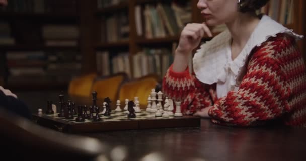 Ένας άντρας και μια γυναίκα παίζουν σκάκι, κάθονται ο ένας απέναντι στον άλλο. — Αρχείο Βίντεο