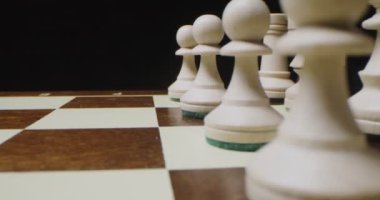 Beyaz satranç taşları bir oyun tahtasında dizilmiş, satranç oynamaya hazır, yakın plan.