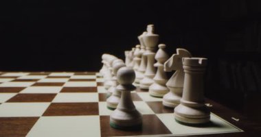 Beyaz satranç taşları bir oyun tahtasında dizilmiş, satranç oynamaya hazır, yakın plan.