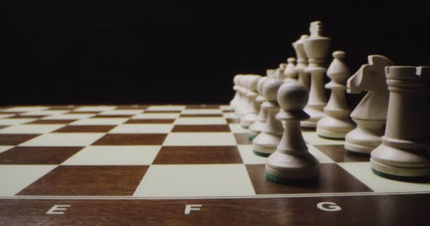 Білі шахові фігури вишиковуються парними рядами на ігровій дошці, готові до гри — стокове відео