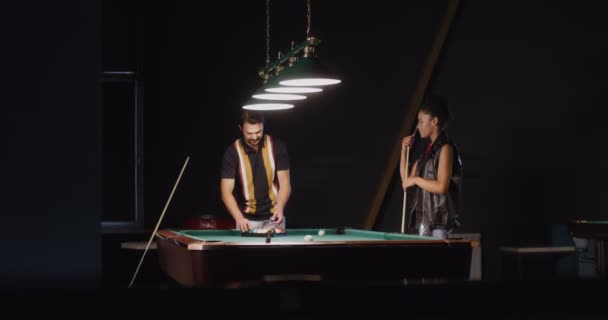 Ung man och kvinna kommer att spela biljard, vikbara bollar i triangeln — Stockvideo