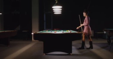 Güzel Afrikalı Amerikalı kadın bilardo kulübünde tek başına bilardo oynuyor.
