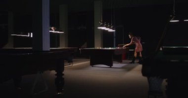 Güzel Afrikalı Amerikalı kadın bilardo kulübünde tek başına bilardo oynuyor.