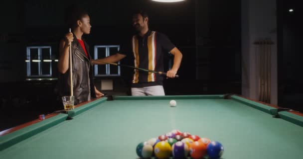 A man shows woman how to hold a cue and break a triangle in billiards — Stock Video