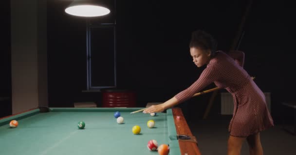 Belle jeune femme afro-américaine joue au billard seul dans un club de billard — Video