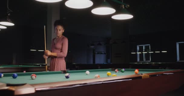 Schöne junge afrikanisch-amerikanische Frau spielt Billard allein in einem Billardclub — Stockvideo