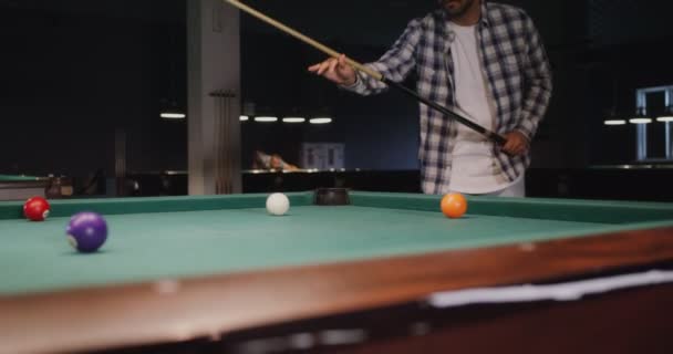 Een man speelt alleen biljart onder schemerlicht in een biljartclub. — Stockvideo