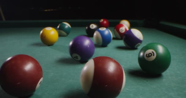 Bolas de bilhar multicoloridas de forma caótica jazem na mesa de bilhar — Vídeo de Stock