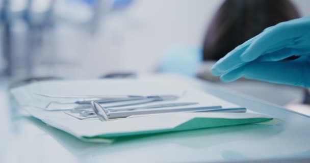 El dentista toma un instrumento médico y comienza un examen de los pacientes — Vídeo de stock