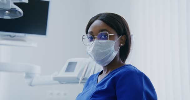 Mujer afroamericana dentista mirando directamente a la cámara, primer plano — Vídeos de Stock