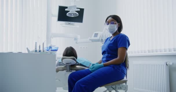 Mujer afroamericana dentista mirando directamente a la cámara, primer plano — Vídeo de stock