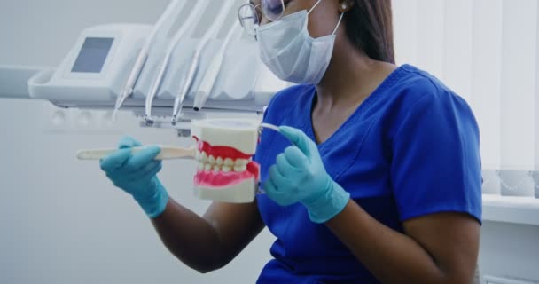 Il dentista afroamericano dimostra al paziente come lavare correttamente i denti — Video Stock