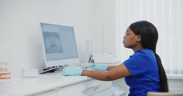 Ο γιατρός εξετάζει την οθόνη του υπολογιστή κατά τη μελέτη στιγμιότυπο των δοντιών των ασθενών — Αρχείο Βίντεο