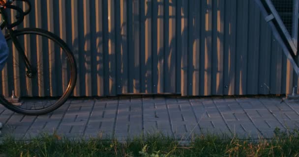 Jongeman die in de herfststad loopt, met de fiets in zijn handen — Stockvideo