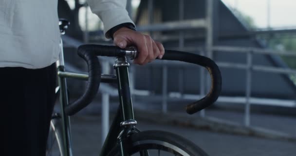 Ein Mann hält ein Fahrrad in der Hand, ein Unbekannter — Stockvideo
