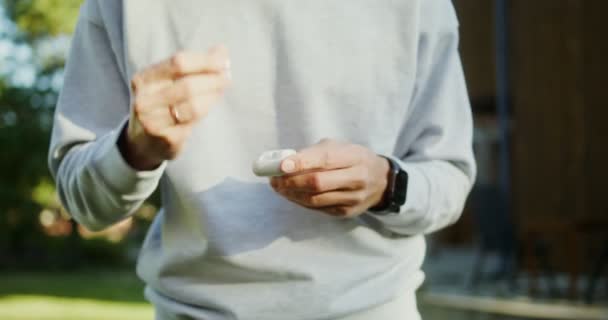 Un joven en ropa deportiva hace ejercicios al aire libre cerca de una mansión moderna — Vídeos de Stock