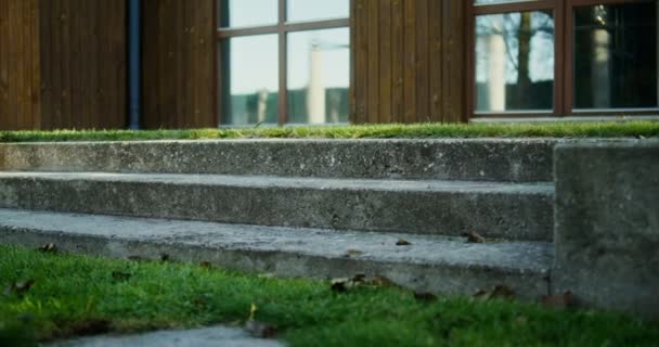 Ein Mann in weißen Turnschuhen steigt eine kleine Treppe hinunter in den Hinterhof, Großaufnahme — Stockvideo