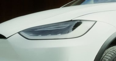 Beyaz elektrikli arabanın farları yakın.