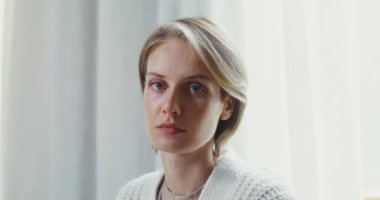 Genç bayan kameraya bakarken gülümsüyor, yakın plan.