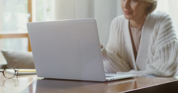 Młoda kobieta kończy rozmowę wideo żegnając się, machając ręką i zamykając laptopa — Wideo stockowe