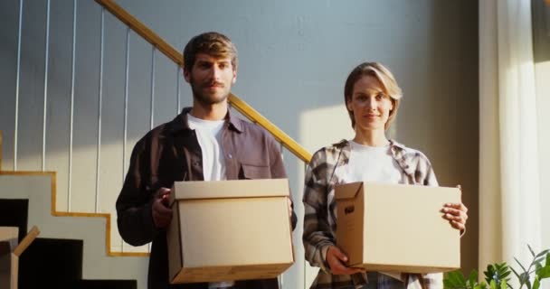 Homem e mulher estão sorrindo enquanto seguram caixas com coisas em suas mãos — Vídeo de Stock