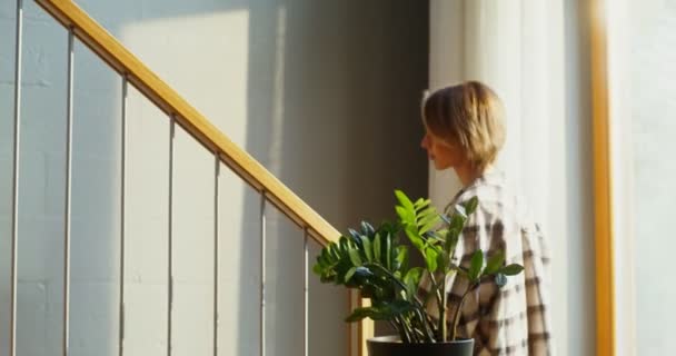 Una joven sube las escaleras de la casa durante la mudanza — Vídeo de stock