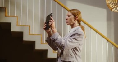 Bir emlakçı kadın tablet kullanarak evin genel bir değerlendirmesini yapar.