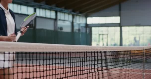 Rivalen begroeten elkaar door handen te schudden over een gestrekt tennisnet — Stockvideo