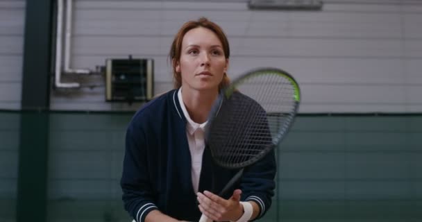 Kvinna tennisspelare väntar på ett pass från motståndare, redo att slå med ett racket — Stockvideo
