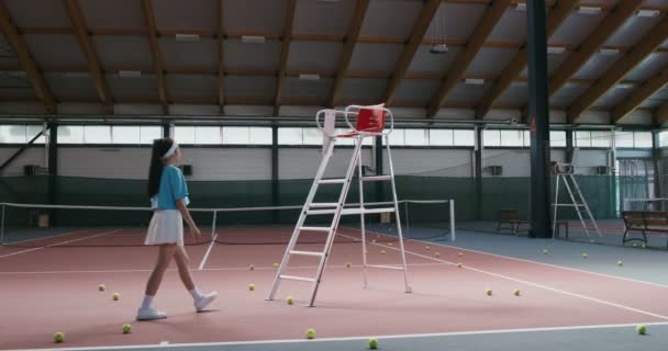 En ung kvinna tennisspelare klättrar uppför trapporna till en domarstol — Stockvideo