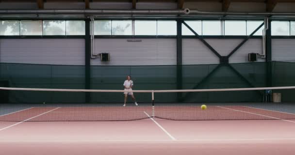 Женщина-теннисистка играет в теннис, бьет по мячу снова и снова — стоковое видео