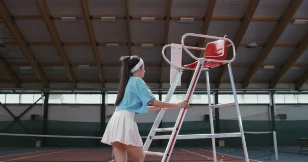Молода жінка тенісистка піднімається по сходах до арбітражного крісла — стокове відео