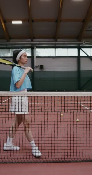 Жінка-тенісистка з тенісною ракеткою позує спираючись на тенісну мережу — стокове відео