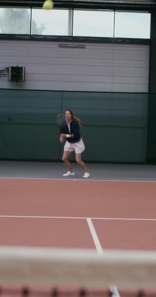 Jugadora de tenis mujer rebota, golpeando una pelota de tenis con una raqueta — Vídeos de Stock