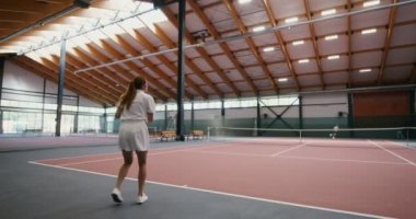 Sporcular topu salonun ortasında gerilmiş bir ağdan birbirlerine atıyorlar.