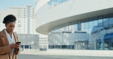 Bir iş kadını cep telefonundan bir telefon numarası çevirir ve bir konuşma başlatır.
