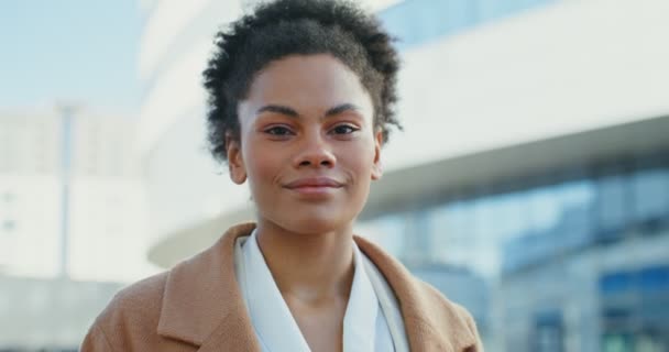 Eine afroamerikanische Geschäftsfrau lächelt in die Kamera und steht draußen — Stockvideo