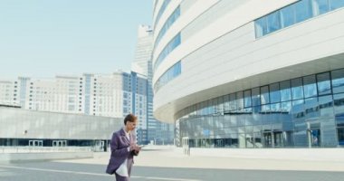 İş elbisesi giymiş bir kadın açık havada ekrana dokunmak için tablet kullanıyor.