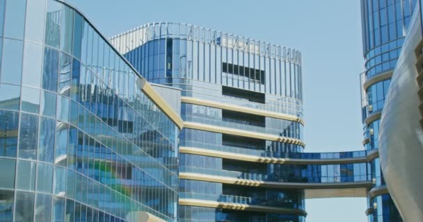 Modernes Bürohochhaus mit Glasfront, in dem sich der Himmel spiegelt — Stockvideo