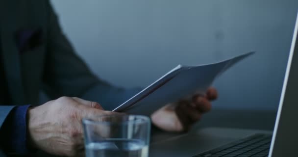 Ein erwachsener Mann geht Papierdokumente durch, sitzt im Büro, Nahaufnahme — Stockvideo