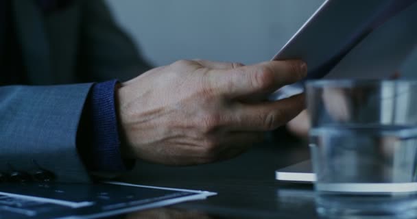 Ein erwachsener Mann geht Papierdokumente durch, sitzt im Büro, Nahaufnahme — Stockvideo