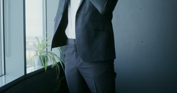 Ein Mann steckt im Büro seine Hand in eine Hosentasche — Stockvideo
